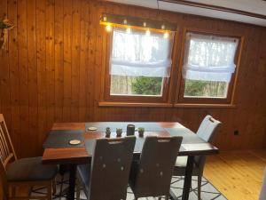 a dining room with a table and some windows at Urige idyllische Hütte mit Sauna in Grainet