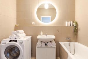 Un baño con lavadora y lavabo. en Magnolie Suite Presidential Garden Free Parking, en Bratislava