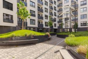 un edificio de apartamentos con una colina de hierba delante de él en Magnolie Suite Presidential Garden Free Parking, en Bratislava