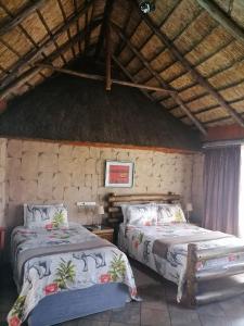 a bedroom with two beds and a stone wall at Lions Rest Guest House and Conference Centre Germiston in Germiston