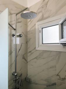 a bathroom with a shower and a window at By the Sea Luxury Apartment in Nikiti