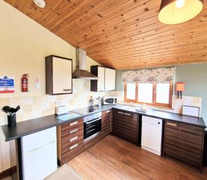 a kitchen with a black counter top and wooden ceilings at Lomond 2 with Private Hot Tub - Fife - Loch Leven - Lomond Hills in Kelty