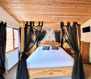 a bedroom with a bed with black curtains at Lomond 2 with Private Hot Tub - Fife - Loch Leven - Lomond Hills in Kelty