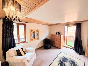 a living room with a white chair and a mirror at Lomond 2 with Private Hot Tub - Fife - Loch Leven - Lomond Hills in Kelty