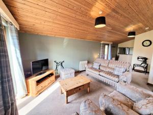 a living room with a couch and a tv at Lomond 2 with Private Hot Tub - Fife - Loch Leven - Lomond Hills in Kelty