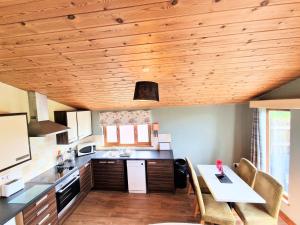 a kitchen with wooden ceilings and a table and chairs at Lomond 2 with Private Hot Tub - Fife - Loch Leven - Lomond Hills in Kelty