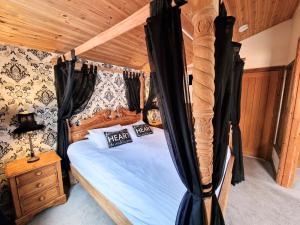 a bedroom with a canopy bed with a wooden ceiling at Lomond 2 with Private Hot Tub - Fife - Loch Leven - Lomond Hills in Kelty +7 photos