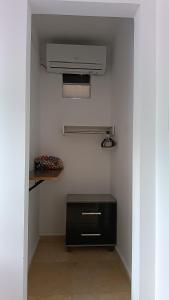a room with a room with a heater and a shelf at Suítes Preguiça in Canoa Quebrada