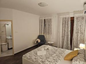 ein Schlafzimmer mit einem Bett, einem Stuhl und einem Spiegel in der Unterkunft Kristy's Place in Crikvenica