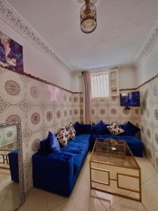 sala de estar con sofá azul y mesa en Dar el omari en Rabat