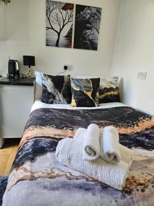 a bedroom with a bed with towels on it at Tiny Studio, 30 min to St. Pancras, North London in London
