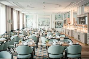 Hotel Atlantic Hamburg, Autograph Collection في هامبورغ: غرفة طعام مليئة بالطاولات والكراسي