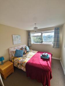 布里德波特的住宿－58 Magdalen Lane，一间卧室配有一张带红色毯子的床和窗户。