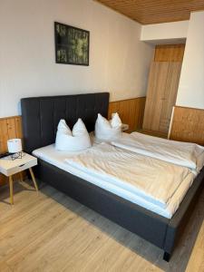 a bedroom with a bed with white pillows at Brauhaus und Pension Babben in Lübbenau