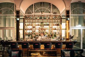 - un bar dans un bâtiment avec un bouquet de chaises dans l'établissement Hotel Atlantic Hamburg, Autograph Collection, à Hambourg