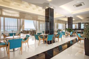 een restaurant met tafels en stoelen en een lobby bij Grand Blue Beach Hotel in Kardamaina