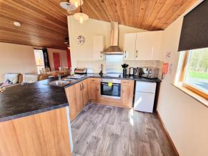 a kitchen with wooden cabinets and a counter top at Lomond 4 with Private Hot Tub - Fife - Loch Leven - Lomond Hills in Kelty +8 photos