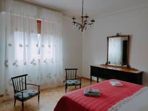 a bedroom with a bed and two chairs and a mirror at Casa ANNA in Montevarchi