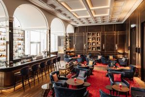 a restaurant with tables and chairs and a bar at Hotel Atlantic Hamburg, Autograph Collection in Hamburg