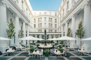 einen Innenhof mit Tischen und Stühlen in einem Gebäude in der Unterkunft Hotel Atlantic Hamburg, Autograph Collection in Hamburg