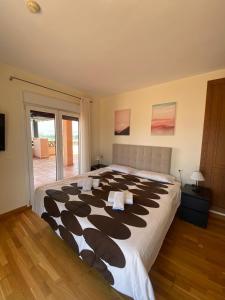 a bedroom with a large bed with black and white sheets at Apartamentos Turísticos Spiritmar in Almerimar