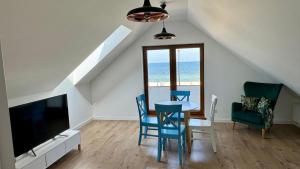 sala de estar con mesa, sillas y TV en SEN NA MIŁEJ - APARTAMENTY przy PLAŻY - GDAŃSK BRZEŹNO, en Gdansk