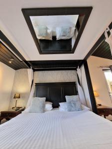 Schlafzimmer mit einem großen weißen Bett und einem Dachfenster in der Unterkunft Ochil 9 with Private Hot Tub - Fife - Loch Leven - Lomond Hills - Pet Friendly in Kelty