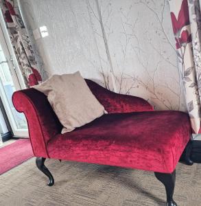 a red couch with a pillow on top of it at Ochil 9 with Private Hot Tub - Fife - Loch Leven - Lomond Hills - Pet Friendly in Kelty