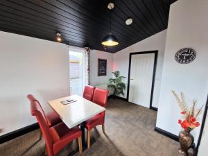 a dining room with a table and red chairs at Ochil 9 with Private Hot Tub - Fife - Loch Leven - Lomond Hills - Pet Friendly in Kelty