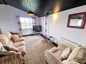 a living room with two couches and a television at Ochil 9 with Private Hot Tub - Fife - Loch Leven - Lomond Hills - Pet Friendly in Kelty +4 photos