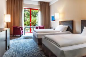 a hotel room with two beds and a table at NH Collection Prague in Prague