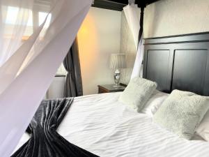 a bedroom with a bed with white sheets and pillows at Ochil 9 with Private Hot Tub - Fife - Loch Leven - Lomond Hills - Pet Friendly in Kelty