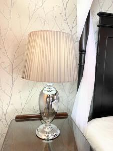 a lamp sitting on a table next to a bed at Ochil 9 with Private Hot Tub - Fife - Loch Leven - Lomond Hills - Pet Friendly in Kelty