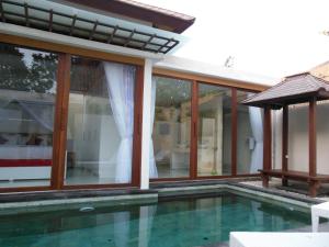 a house with a swimming pool and windows at HK Villa Bali in Legian