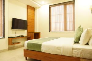 SoonStay Heera Residency في بوبال: غرفة نوم بسرير وتلفزيون بشاشة مسطحة