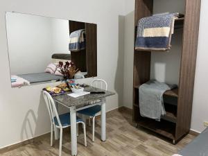 a small room with a table and chairs and a mirror at Ribas Pousada e Camping in Carambeí +35 photos