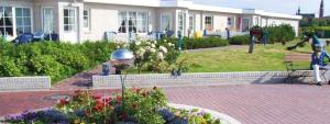 a woman sitting on a bench in front of a house at Ferienwohnung-Eilts-Whg-09 in Borkum