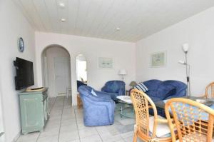 a living room with blue chairs and a table at Ferienwohnung-Eilts-Whg-09 in Borkum