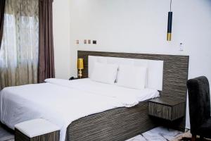 1 dormitorio con 1 cama grande y 1 silla en MO-House Hotels and Apartments Mabushi, en Abuja