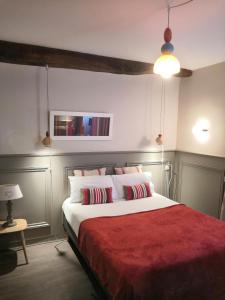 1 dormitorio con 1 cama grande con manta roja en Hôtel La Caravelle, en Ciboure