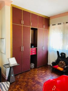 uma sala de estar com armários roxos e um sofá vermelho em Casa de Roy em Kampala