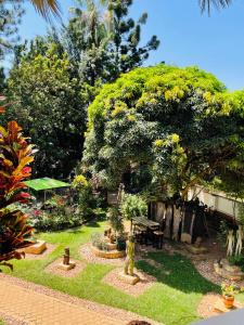 um jardim com uma mesa de piquenique e uma árvore em Casa de Roy em Kampala