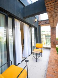 a balcony with yellow chairs and a table and windows at Zarafa Suites in Nairobi
