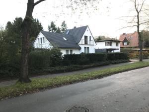 una casa blanca con techo negro en una calle en Ruhige Doppelhaushälfte mit 5 Schlafzimmern im Villenviertel en Hamburgo