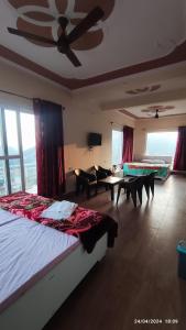 1 dormitorio con 1 cama grande y sala de estar en Host Labs Homestay - Premium View - Close to Kaichi Dham, Bhimtal, Sattal, and more, en Bhimtal
