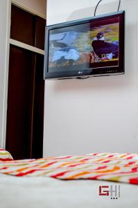 TV de pantalla plana colgada en la pared en Grand Hotel en San Fernando del Valle de Catamarca
