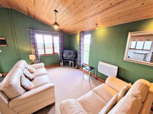 a living room with two couches and a television at Ochil 8 with Private Hot Tub - Fife - Loch Leven - Lomond Hills in Kelty