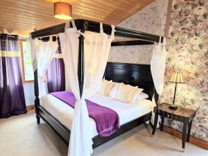a bedroom with a canopy bed with purple sheets at Ochil 8 with Private Hot Tub - Fife - Loch Leven - Lomond Hills in Kelty +4 photos