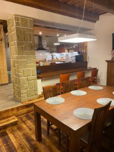 a dining room with a table and chairs and a kitchen at Chalet Hronec in Hronec