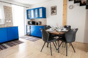a kitchen with blue cabinets and a table and chairs at Island Apartments in Izola